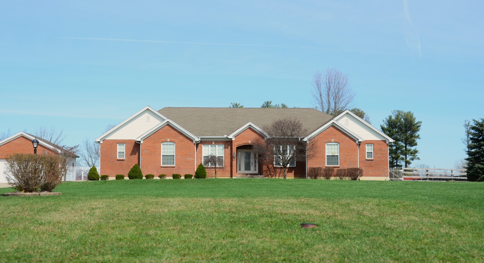 Brick house with mildew-free siding and clean walkway after a soft-wash service.